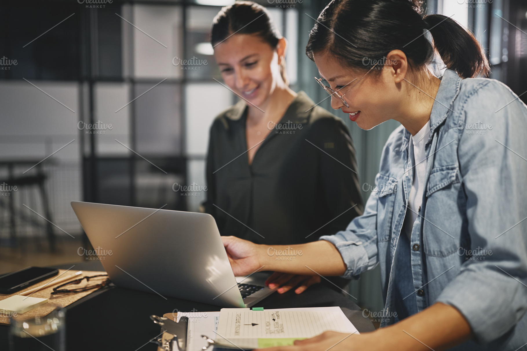 Smiling businesswomen working togeth containing adults, agency, and asian, a Business Photo by Stefan & Janni