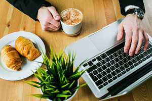 Coffee croissants and computer containing coffee, cup, and computer