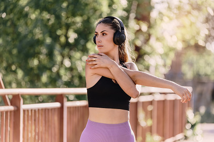 Young woman stretching arms with hea, a Sports & Recreation Photo by Perpis