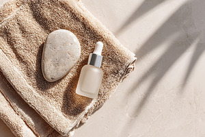 Skincare essentials on a beige surface with calming shadows cast by sunlight, a Beauty & Fashion Photo by AlyaAnd