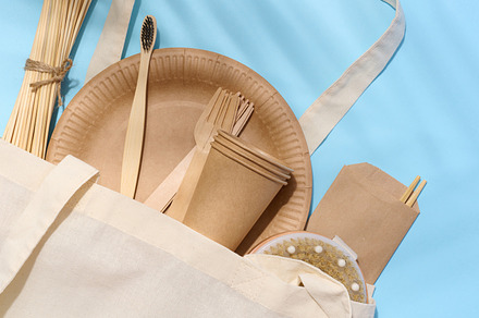White cotton bag, wooden forks, plates and cups on a blue backgr, a Food & Drink Photo by ndanko