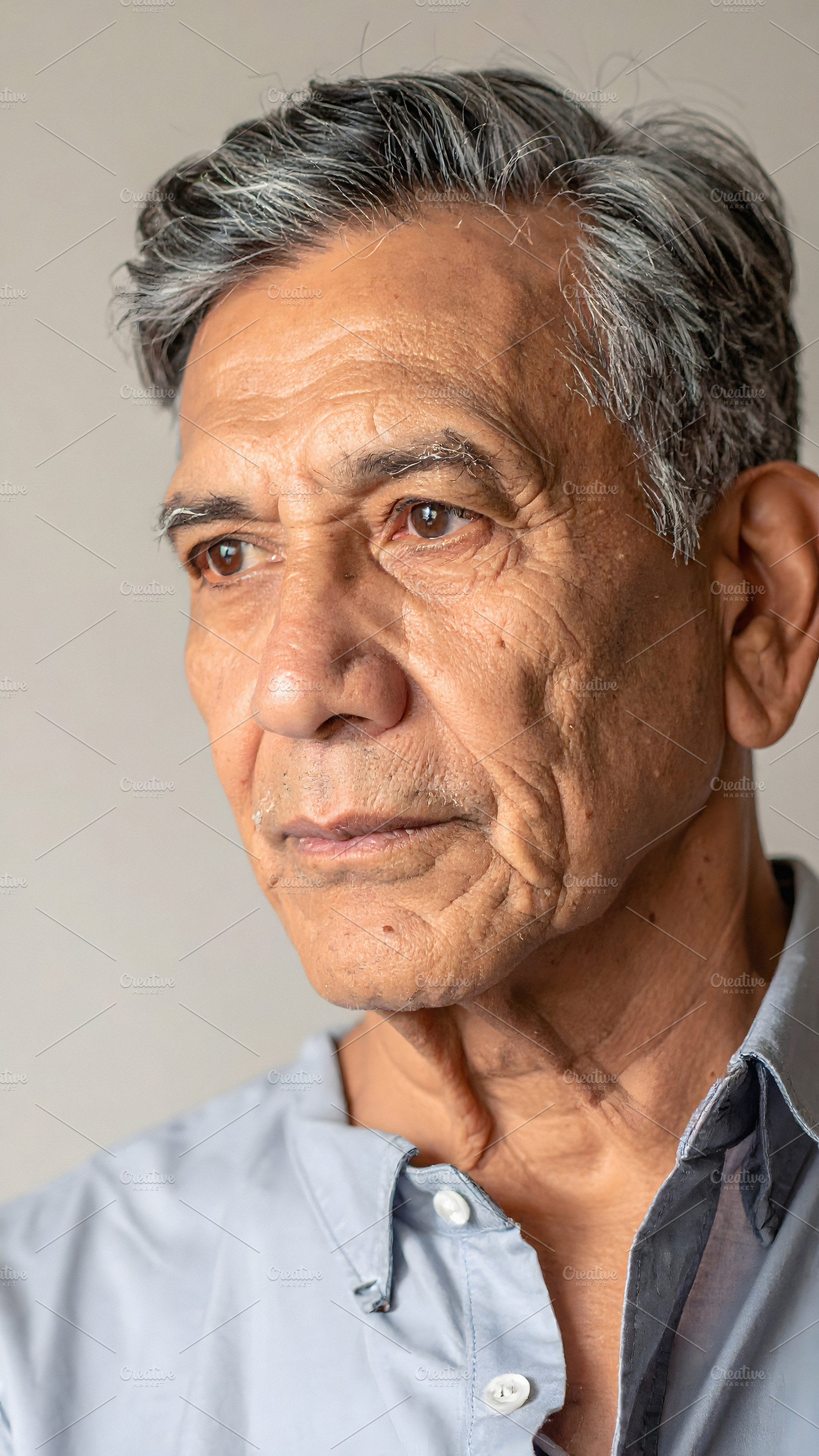 Thoughtful senior man gazing sideways with gentle expression, a Person Photo by GoodGoods