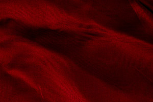 Close-up of soft, rich red fabric with gentle folds and subtle s, a Background Photo by Ales Munt
