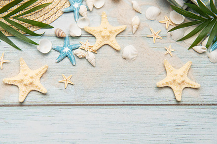 Summer accessories creating a frame on a wooden background with