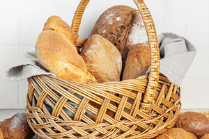 Wicker basket holding fresh bakery bread and rolls, a Food & Drink Photo by Olena Rudo