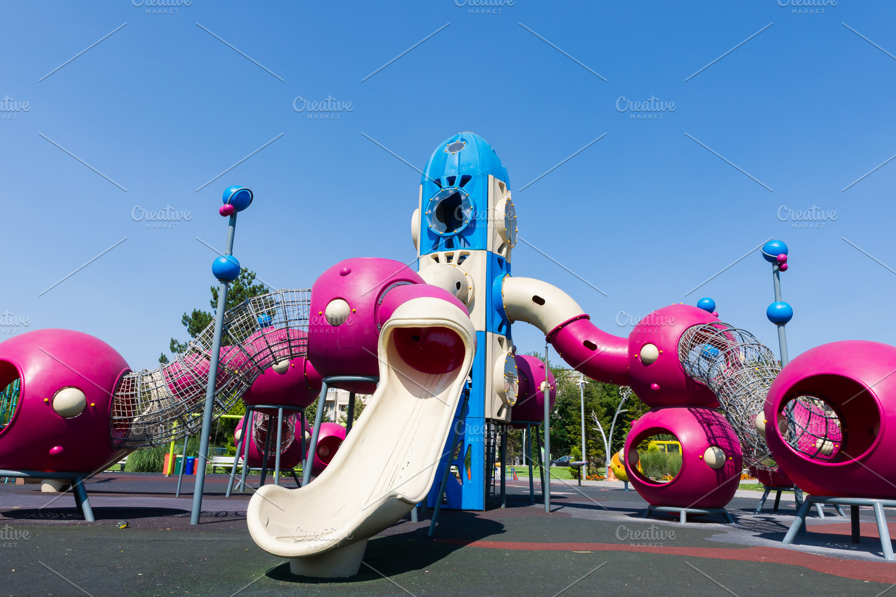 Colorful outdoor playground featuring a rocket-shaped slide, climbing tunnels,, a Sports & Recreation Photo by Ales Munt