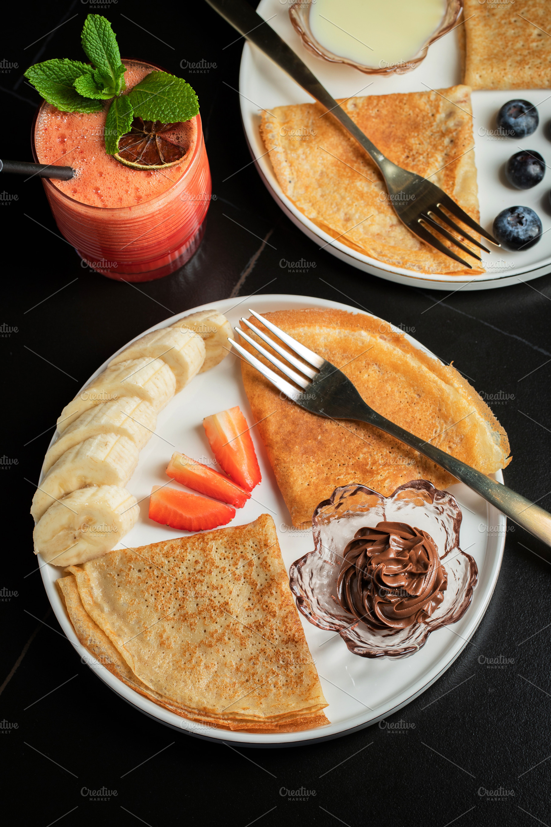 A plate of crepes filled with chocolate spread and topped with banana slices an, a Food & Drink Photo by Budarinphoto