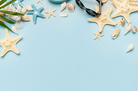 Summer accessories creating a frame on light blue background wit