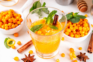 Sea buckthorn cocktail with fresh berries, cinnamon spices, hone, a Food & Drink Photo by Rimma