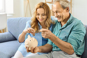 Couple Saving Coins in Piggy Bank