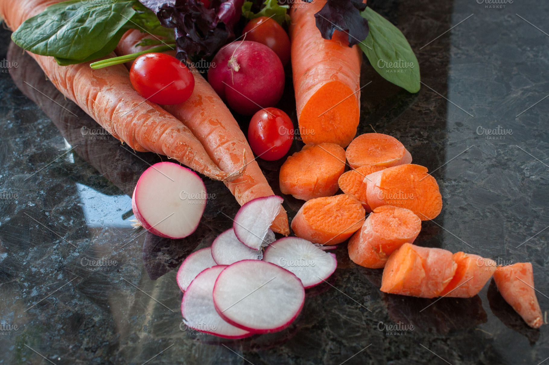 Fresh vegetables containing carrot, radish, and tomato