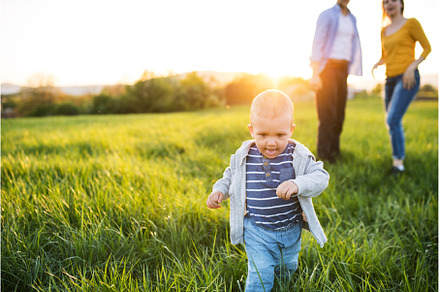 Cute toddler running in front of, a Person Photo by HalfPoint