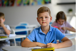 School boy sitting at the desk in, a Person Photo by HalfPoint