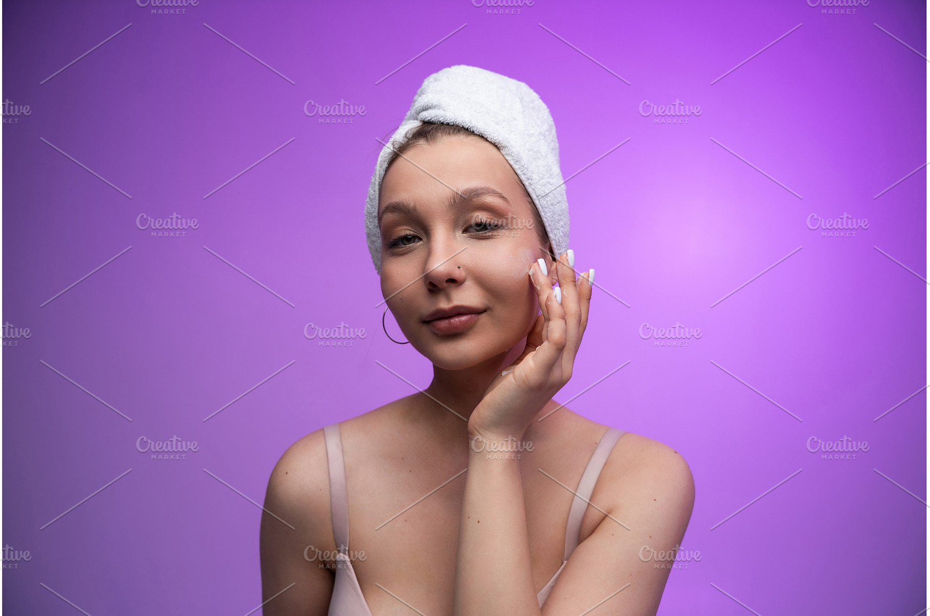 Young woman applying face cream, a Health & Medical Photo by volodymyrshtun13795