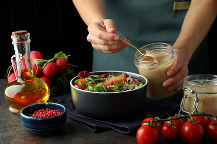 Concept of cooking vegetable salad with tahini sauce on dark tex, a Background Photo by AtlasStudio PRO