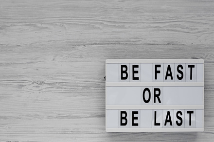 'Be Fast or Be Last' on a lightbox on a white wooden background,, a Business Photo by LiudmylaChuhunova