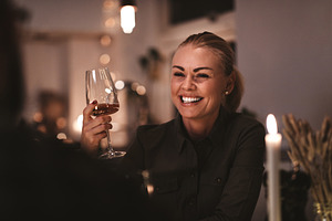 Laughing woman talking with a friend at a dinner party