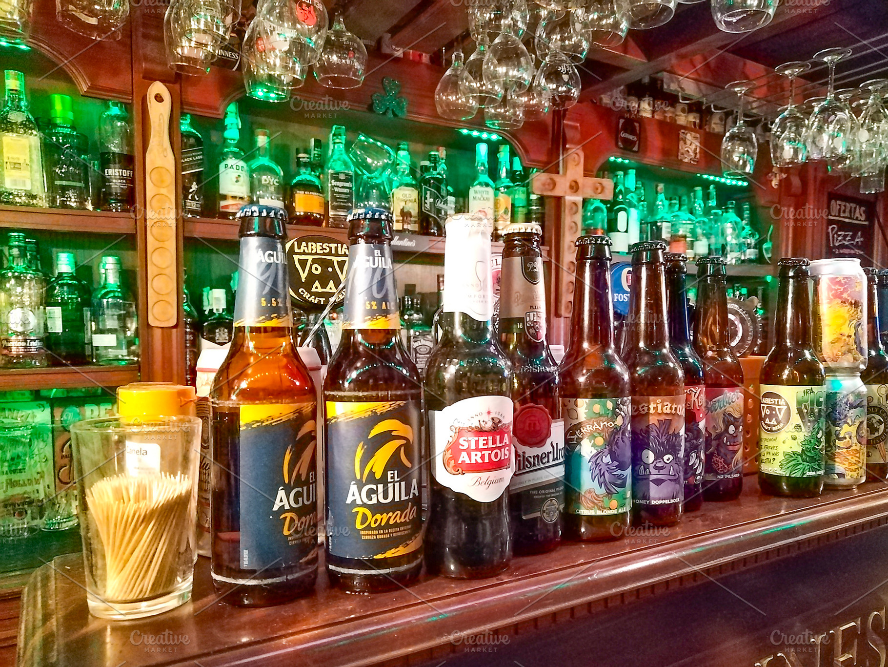 Beer selection at traditional bar counter, a Food & Drink Photo by DanFLCreativo