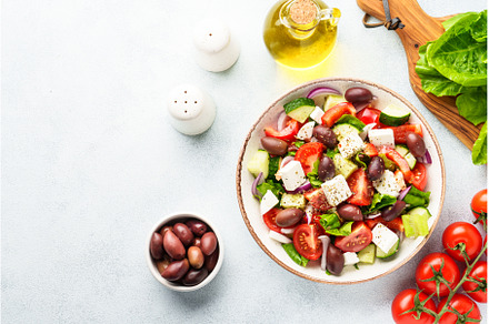 Greek salad in craft plate on white