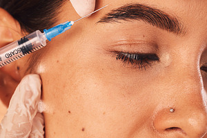 Botox, hands and woman in beauty surgery procedure for skincare, change and collagen filler, calm and content. Plastic surgery, girl and hands of surgeon with needle for treatment, lift and makeover, a Photo by Peopleimages.com