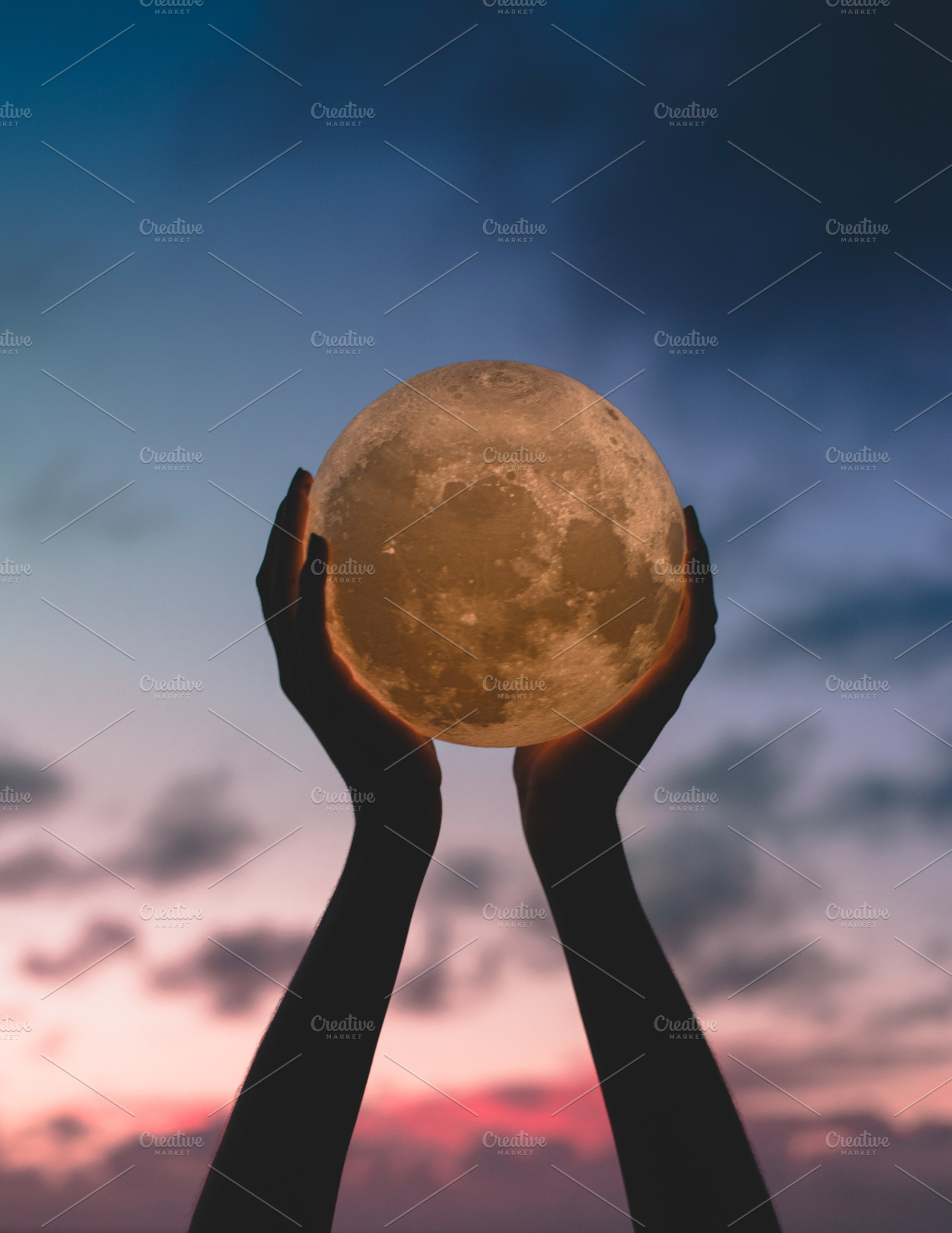 Hands holding up moon stock photo containing sky and clouds, a Person Photo by Fossilized Tree Sap