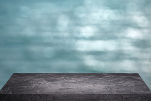 Black stone surface on blurry blue background.