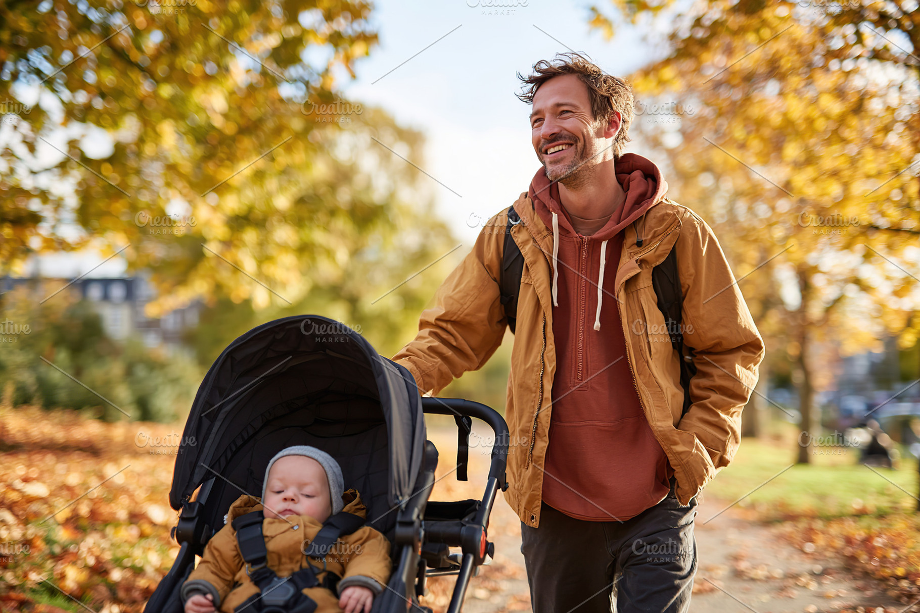 Father enjoys a sunny autumn walk with baby in stroller through park covered in, a Person Photo by AlyaAnd