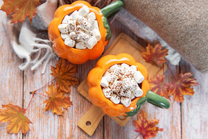 Pumpkin mugs filled with hot chocolate warming up for fall, a Food & Drink Photo by Olena Rudo