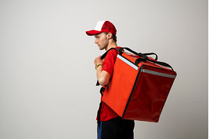 Food delivery man in red uniform, a Business Photo by volodymyrshtun13795
