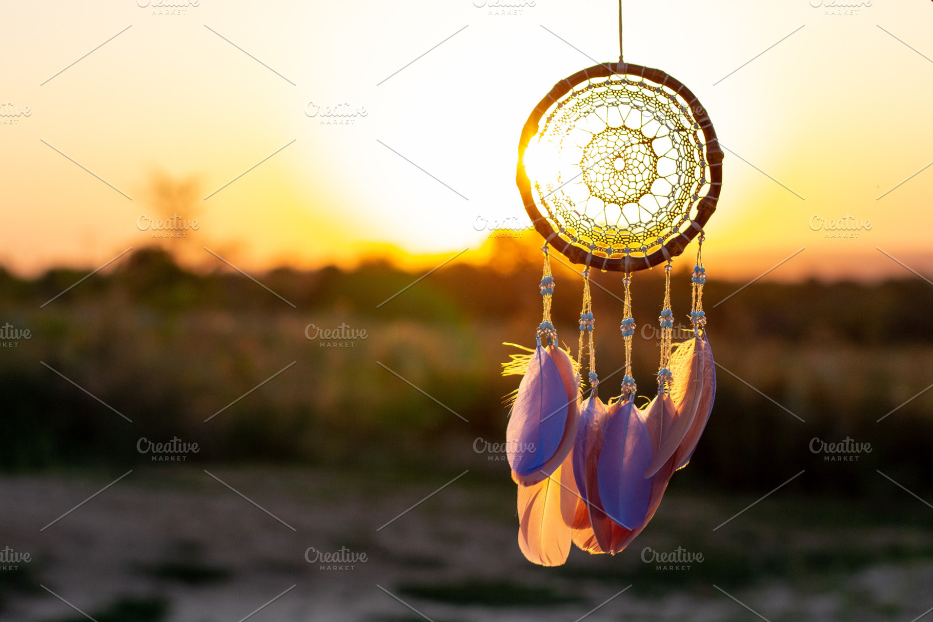 Handmade dream catcher with feathers threads and beads rope hanging, a Background Photo by dashtik