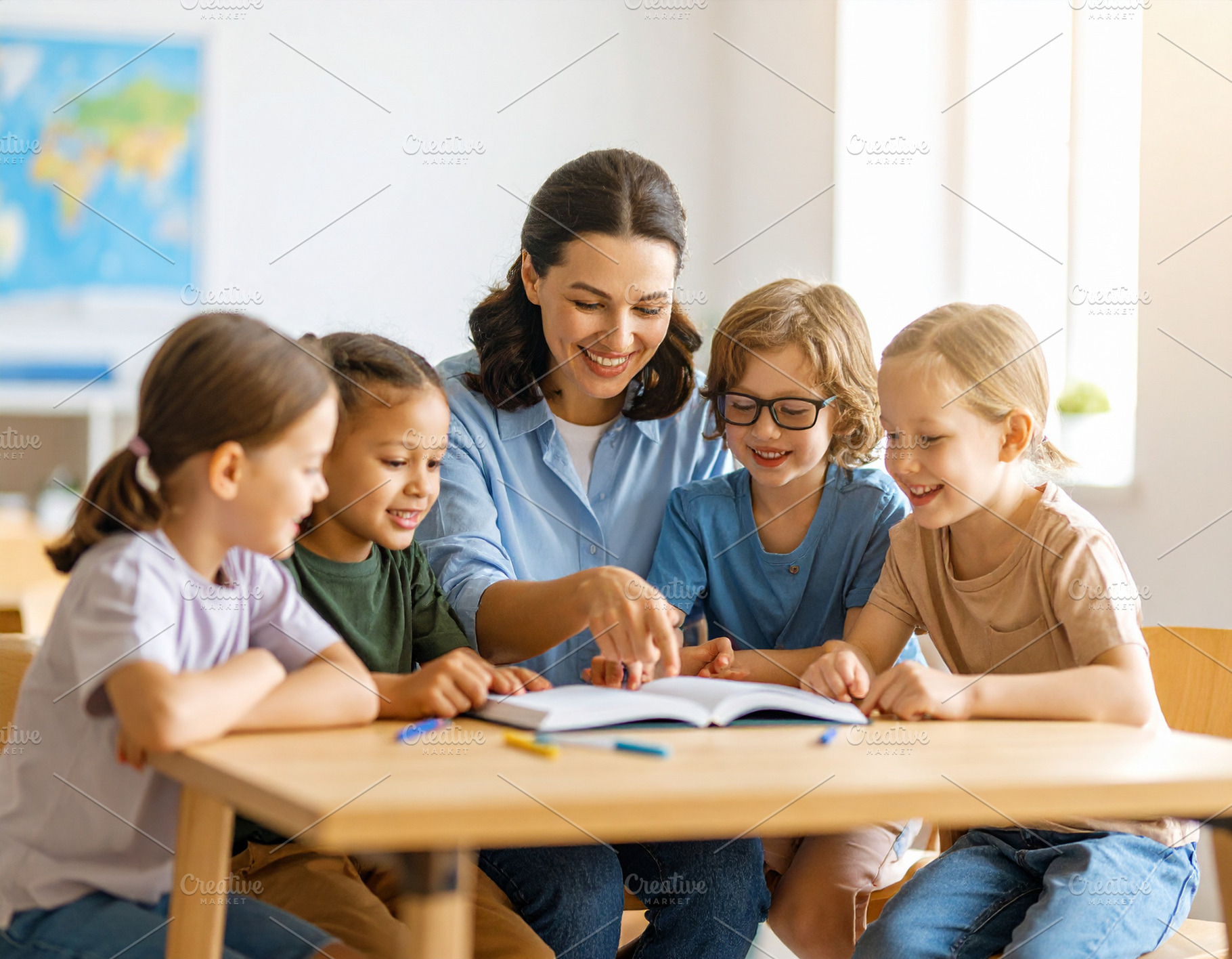 Teacher with a small group of children in a classroom pointing a, a School & Education Photo by DanFLCreativo