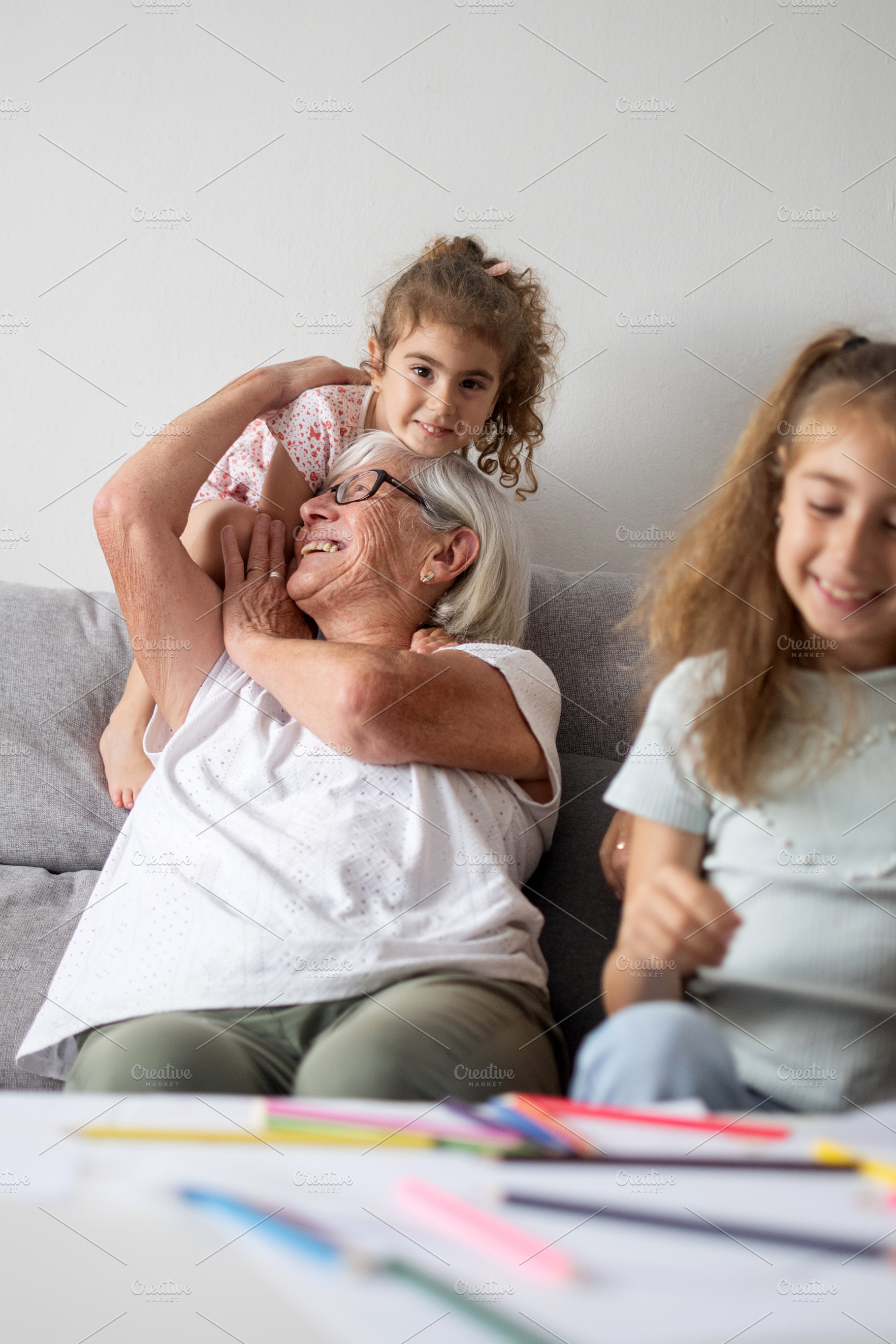 Grandmother playing and laughing with her granddaughters at home, a Person Photo by etorres69