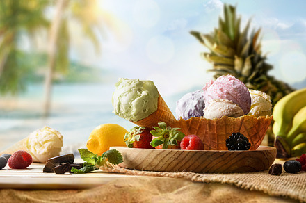 Assorted fruit ice-cream on wooden table on sand with beach, a Food & Drink Photo by Davizro's Market
