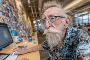 Senior man with white beard working on a computer in a bright modern office cre, a Photo by AS photostudio
