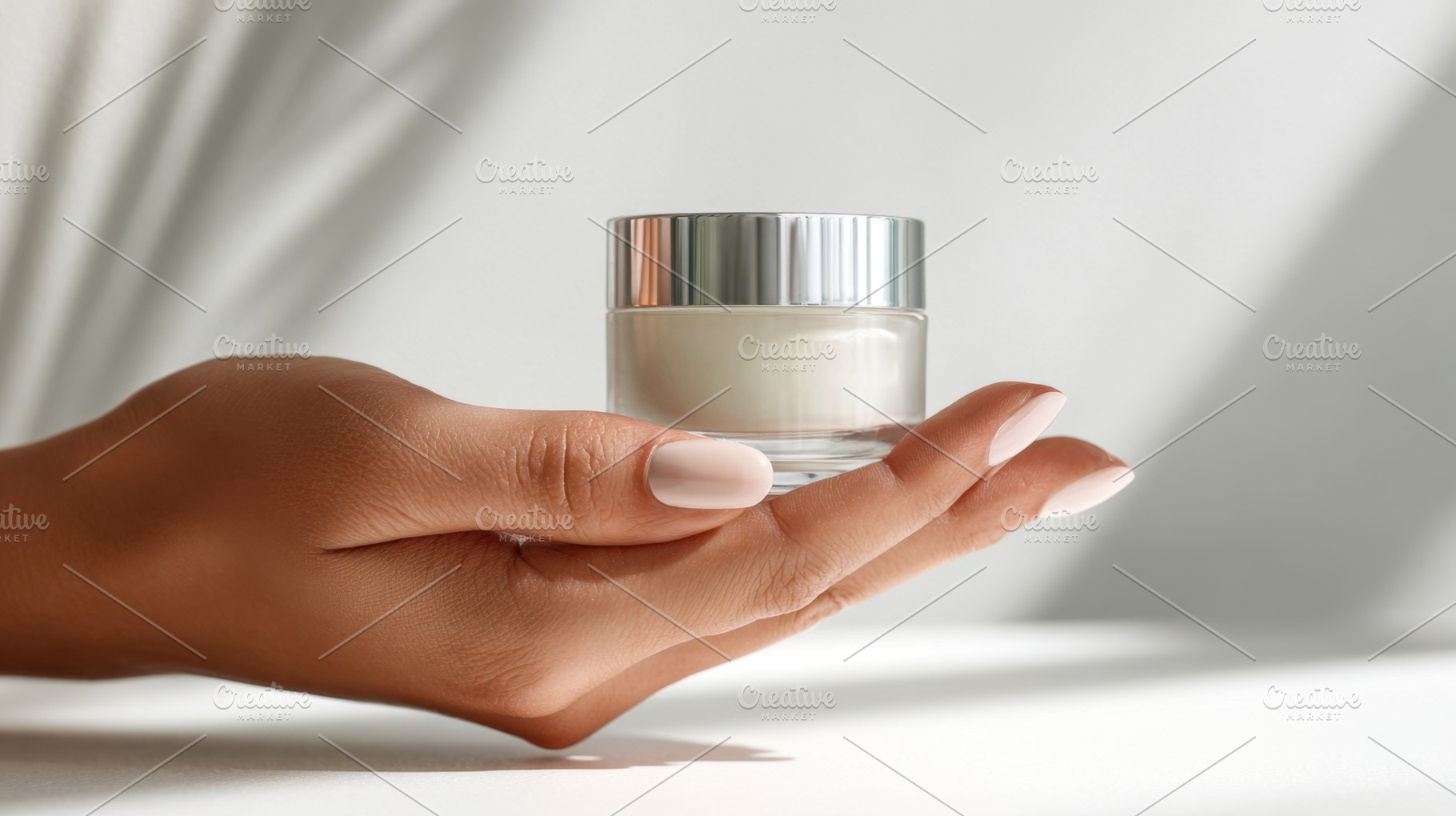 Hand holds a clear jar of cream, a Photo by Beautiful things