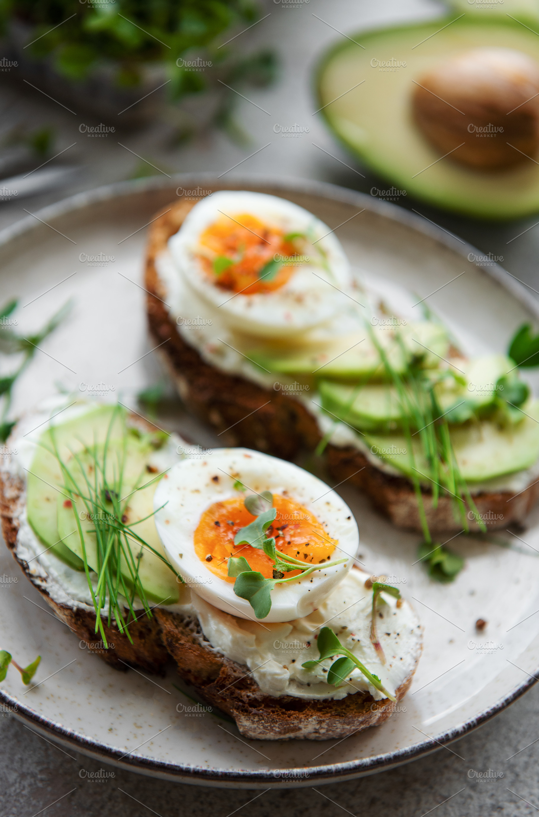Bread toast, boiled eggs, avocado slice, microgreens on a plate, a Food & Drink Photo by Olena Rudo