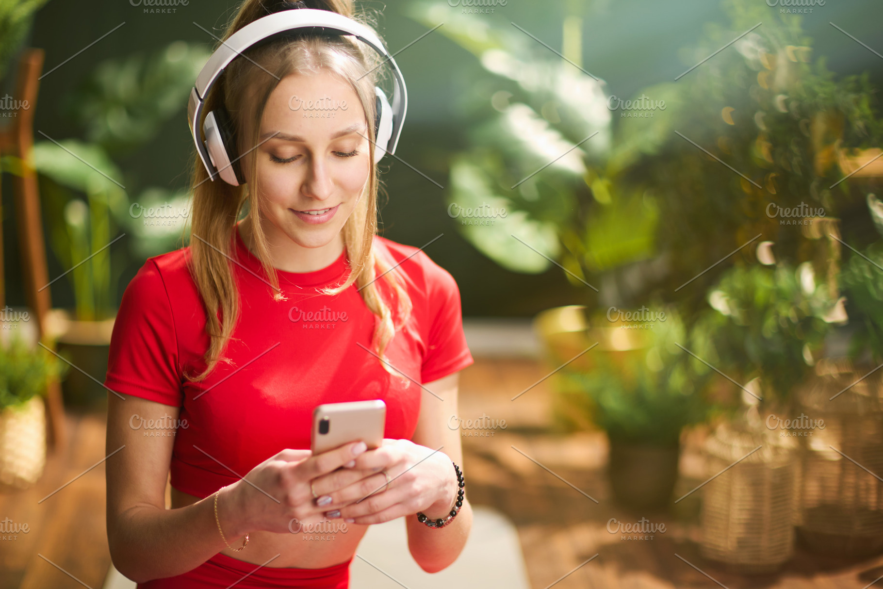 smiling female in red fitness clothes in green house, a Person Photo by Alliance Images