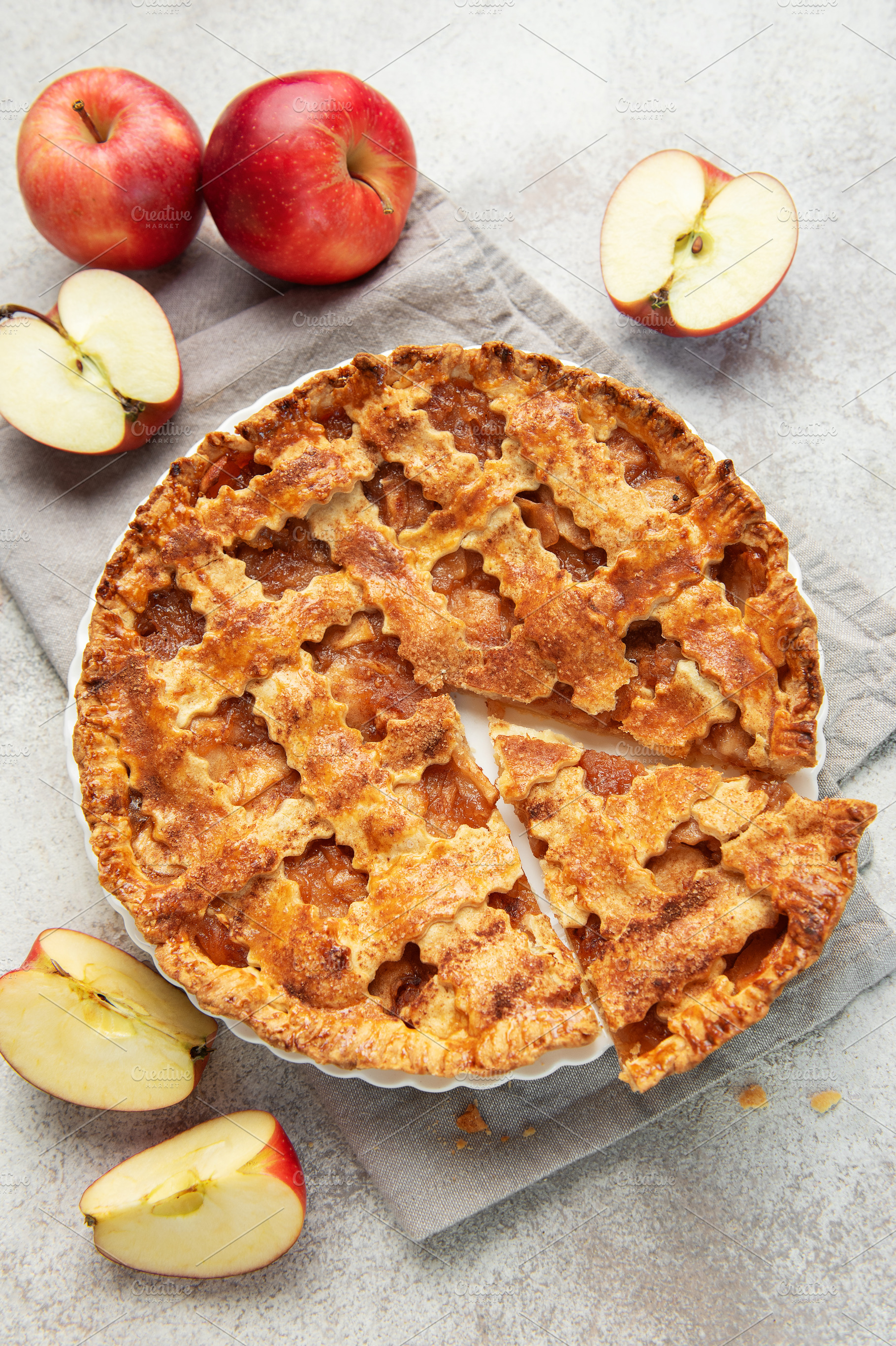 Freshly baked apple pie with a slice missing and apples beside, a Food & Drink Photo by Olena Rudo