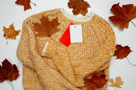 Autumn clothing sales. Warm golden sweater with mock up label. Top view. Copy s, a Photo by matucha