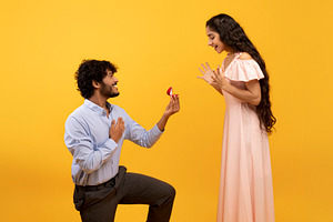 Loving indian man standing on one knee and offering engagement ring to his belo, a Person Photo by Prostock-Studio