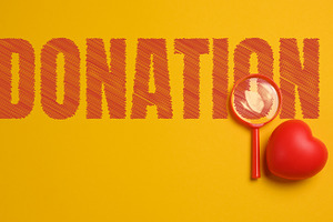 A composition with the word DONATION, a red magnifying glass,, a Photo by ndanko