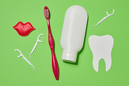 Red toothbrush, white tube of toothpaste, red decorative lips, p
