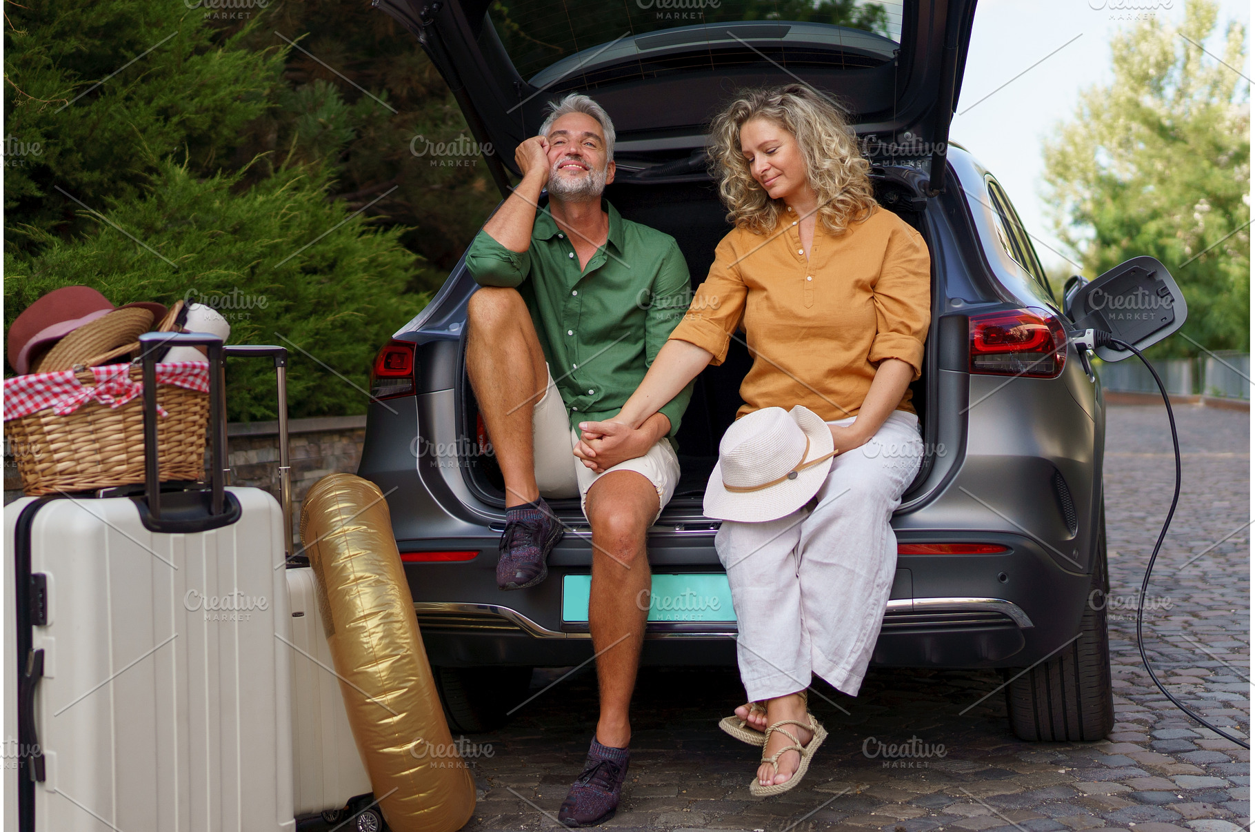 Middle-aged couple sitting in trunk, a Person Photo by HalfPoint