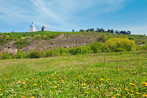 Spring blossoming field and ancient fotess and church behind, a Nature Photo by YuriyB