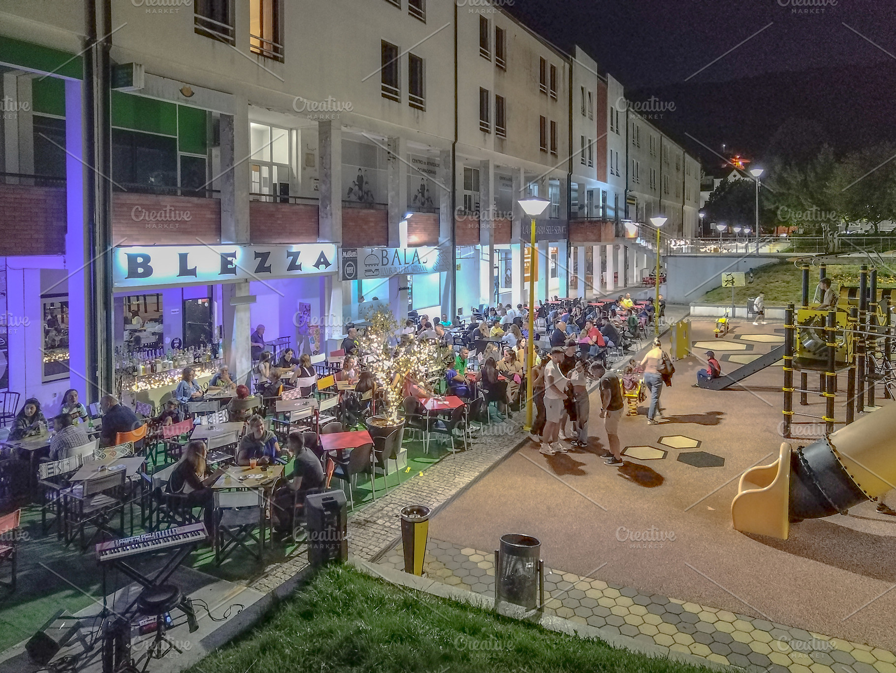 Night gathering with crowd in public plaza, vila pouca de aguiar, a Photo by DanFLCreativo