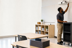 Classroom setup with man adjusting p, a Photo by Dvoevnore photos