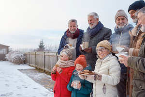 Family gathering in snowy yard with hot drinks, a Person Photo by DanFLCreativo