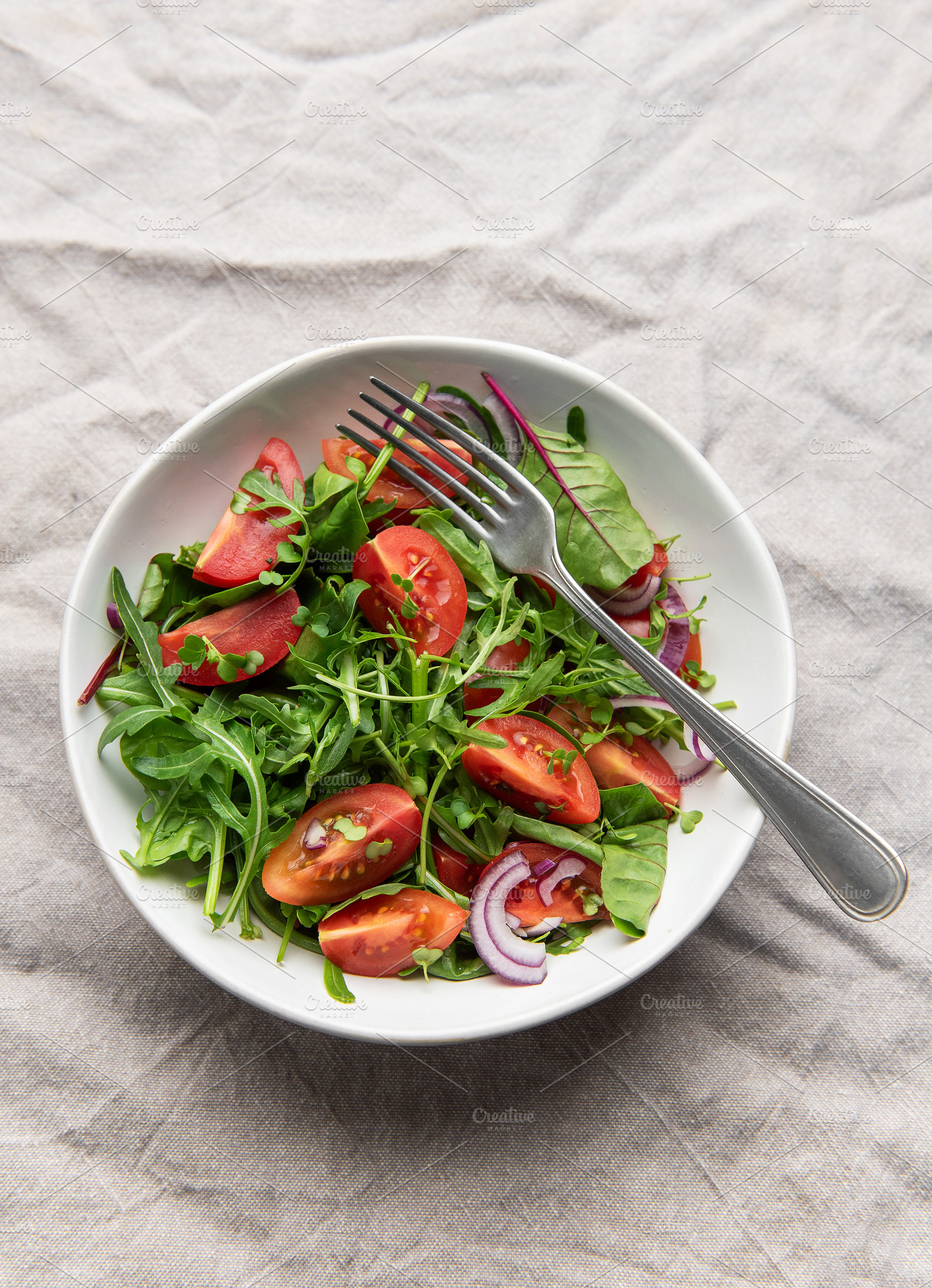 Fresh garden salad with tomatoes, arugula, and onion, a Photo by Olena Rudo