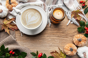 Autumn flat lay with coffee, candle, and pumpkins