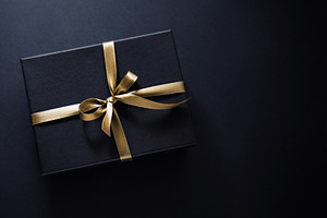 Gift wrapped in dark paper on dark b stock photo containing wrapping and